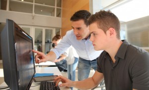 Teacher and student working on computer